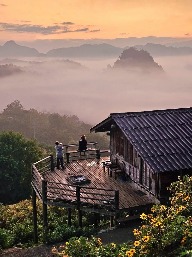 เรือนไม้และลานระเบียงของร้านบนไหล่เขาตอนพระอาทิตย์ขึ้น