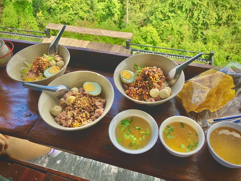 ก๋วยเตี๋ยวหลายชามกับถ้วยน้ำซุปเต็มเคาน์เตอร์ริมระเบียง